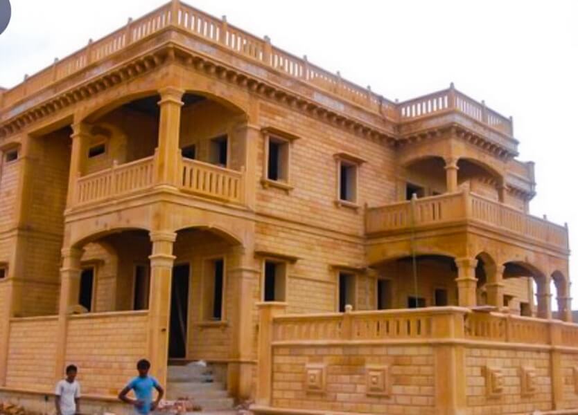 Exterior view of a stone bungalow with garden