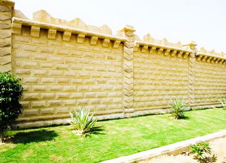 Traditional stone compound wall with intricate detailing